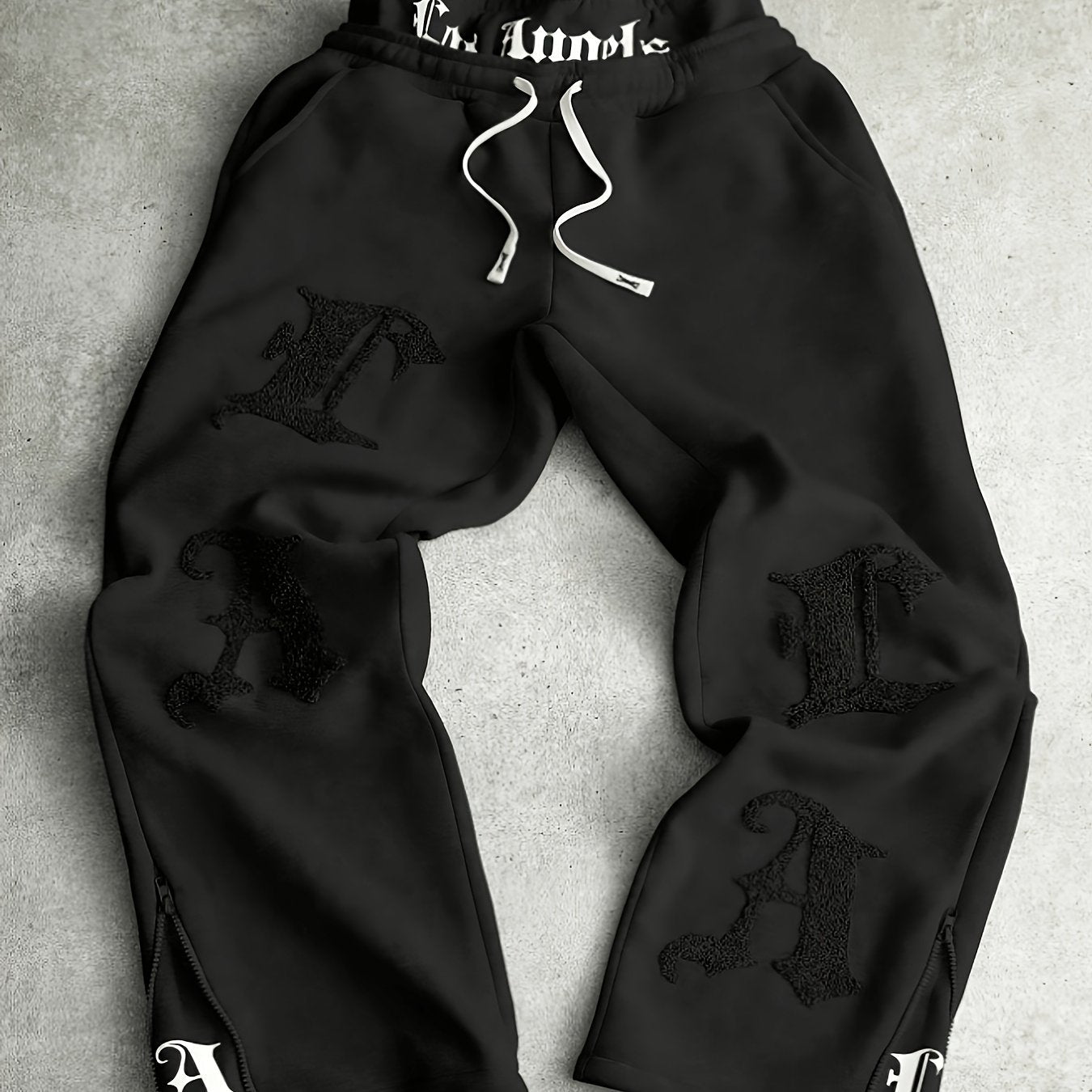Loose-fit men's joggers with embroidered lettering on the legs, drawstring waistband, black