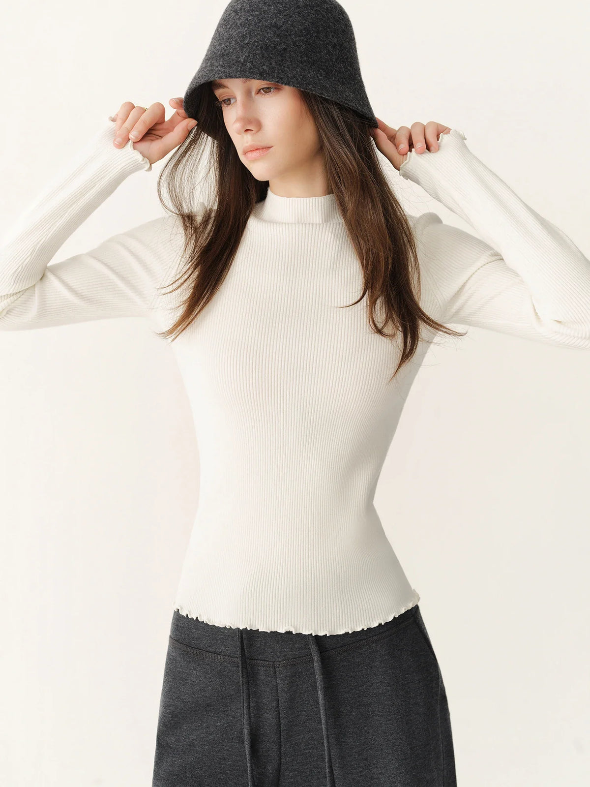 Women's ribbed long-sleeve top with stand collar and ruffled hem
