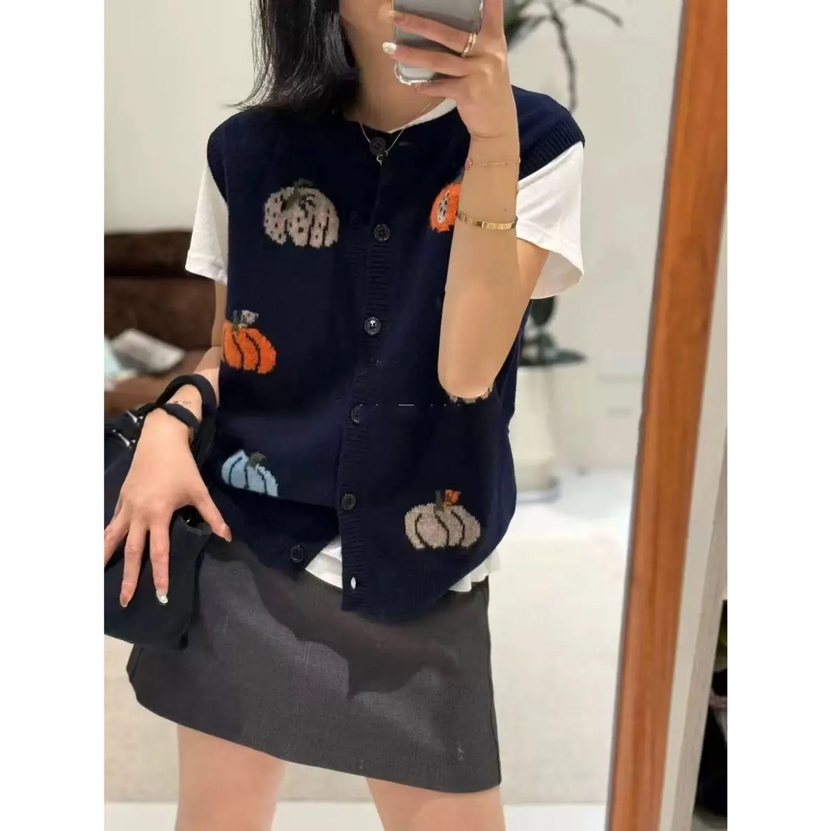 Women's knitted vest with pumpkin motifs, button placket, and round neckline
