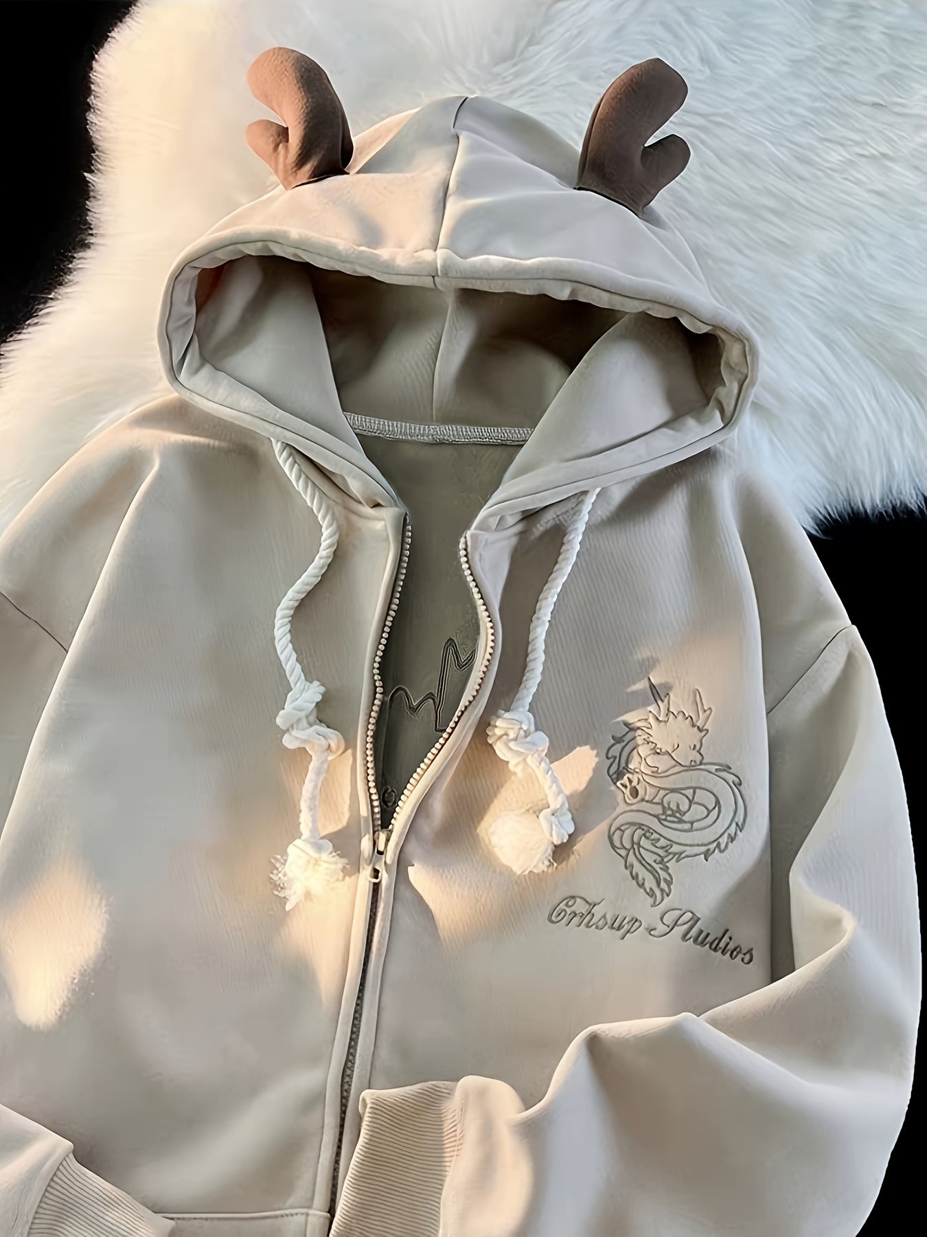 Beige zip-up hoodie with dragon embroidery and antler hood