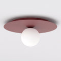 Ronde bordeauxrode plafondlamp met één witte glazen bol aan een wit plafond