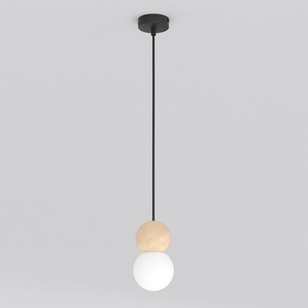 Zwarte hanglamp met houten bol en witte glazen kap aan een dun zwart snoer, tegen een lichtgrijze achtergrond