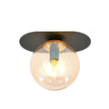 Zwarte ovale plafondlamp met ronde amberkleurige glazen kap en brandende lichtbron