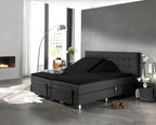 Zwart splittopper hoeslaken op een verstelbaar boxspringbed met antracietkleurig hoofdbord in een moderne slaapkamer