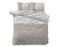 Dekbedovertrek met geometrische print in taupe, wit en zwart, met twee bijpassende kussens op het bed
