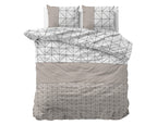 Dekbedovertrek met geometrische print in taupe, wit en zwart, met twee bijpassende kussens op het bed