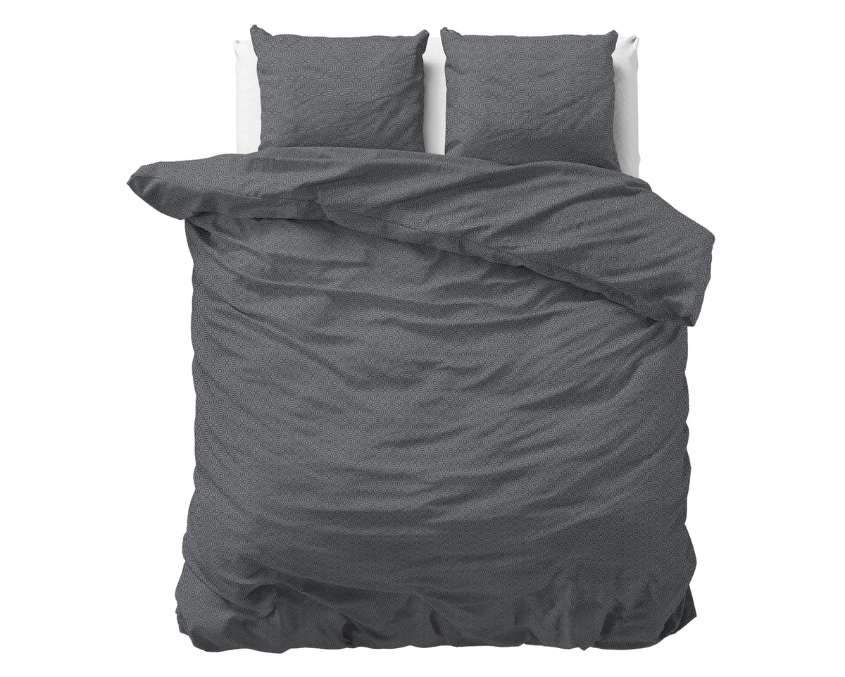 Antraciet dekbedovertrek met subtiel geometrisch dessin en twee bijpassende kussens op een bed