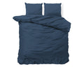 Marineblauw dekbedovertrek met twee bijpassende kussens op een bed, effen met subtiel geëmbosseerd effect