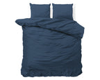 Marineblauw dekbedovertrek met twee bijpassende kussens, bovenaanzicht op een bed