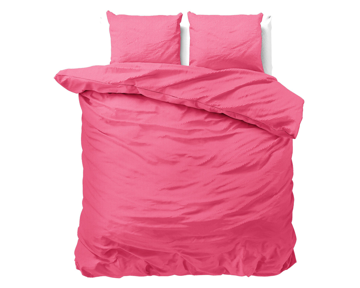 Roze dekbedovertrek met twee bijpassende kussens op een bed, met omgeslagen dekbed