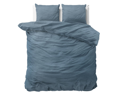 Blauw stonewashed dekbedovertrek met twee bijpassende kussens op een bed, bovenaanzicht