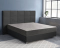 Grijs satijnen hoeslaken om een matras op een bed met donker gecapitonneerd hoofdbord in een slaapkamer