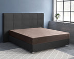 Taupe satijnen hoeslaken op een bed met donkergrijs gestoffeerd hoofdbord en boxspringbasis in een slaapkamer met blauwe muur