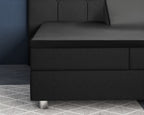 Zwart satijnen hoeslaken om een topper op een zwarte boxspring met gecapitonneerd hoofdbord