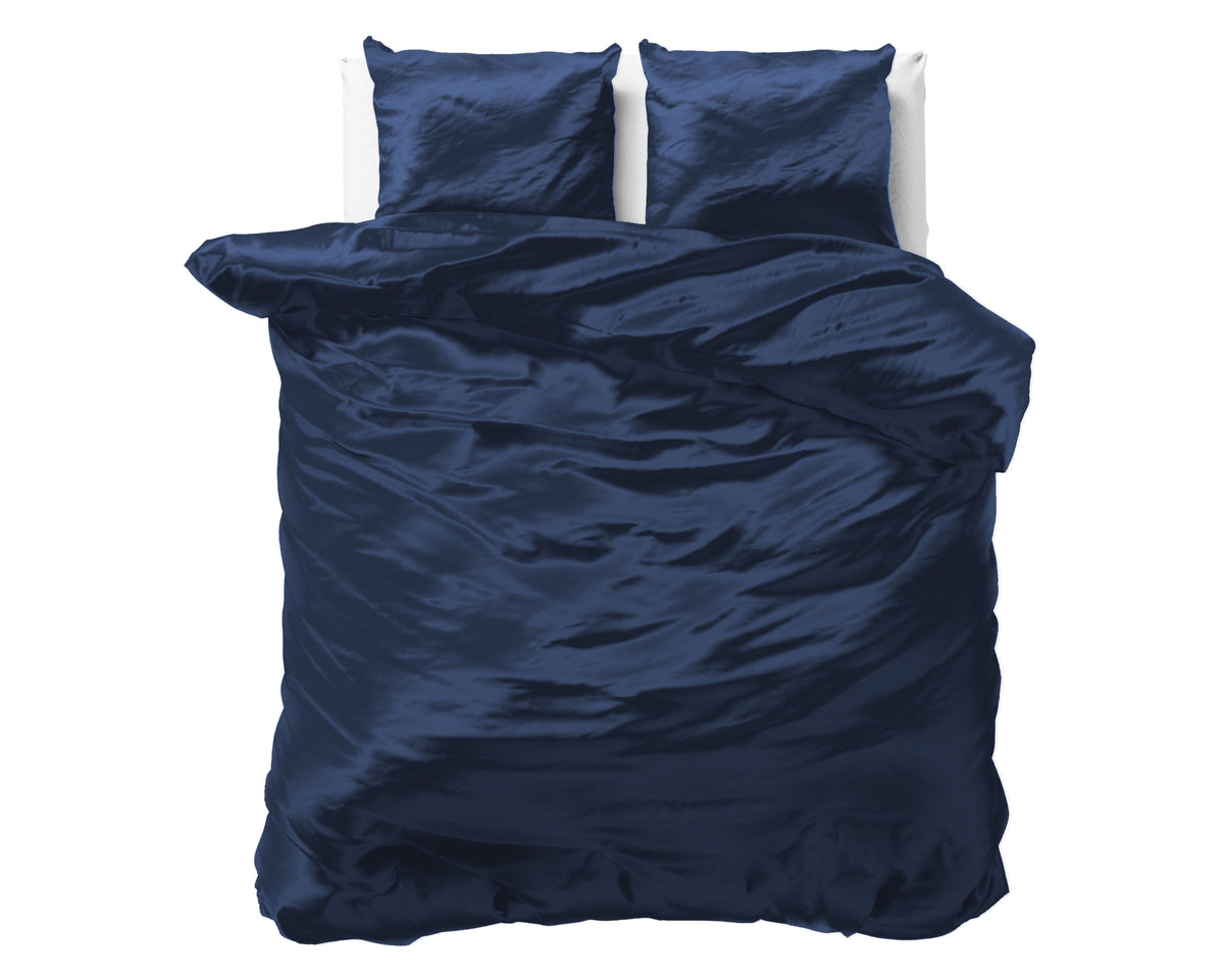 Marineblauw satijnen dekbedovertrek met twee bijpassende kussenslopen op een bed