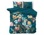 Blauw dekbedovertrek Chanda met bloemenprint in roze, geel en lichtblauw en twee bijpassende kussens op een bed