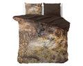 Dekbedovertrek met taupe print en goudkleurige accenten, omgeslagen met effen bruine binnenzijde en twee kussens op bed