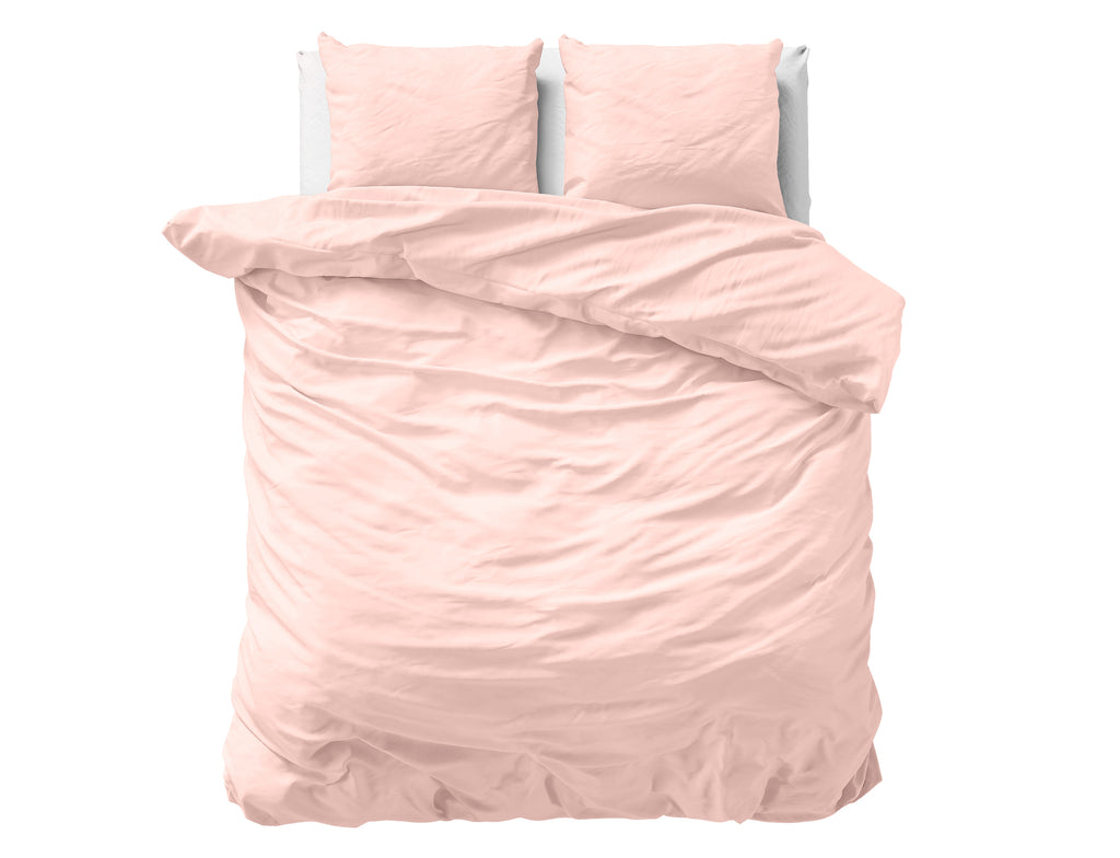 Roze effen dekbedovertrek van satijn met twee bijpassende kussens op een bed, gezien van boven