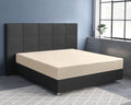 Zandkleurig hoeslaken van katoensatijn op een matras met donkergrijs gestoffeerd hoofdbord en boxspringonderstel