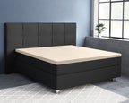 Zandkleurig topper-hoeslaken op een donkergrijs boxspringbed met gecapitonneerd hoofdbord in een blauwe slaapkamer