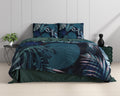 Bed met blauw dekbedovertrek met botanische bladprint en effen groene achterzijde, naast een plant en groene poef