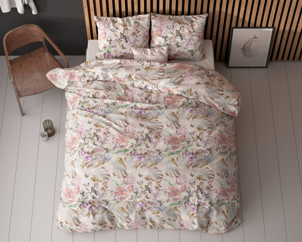 Dekbedovertrek met roze bloemenprint, vlinders en bladeren op een bed met twee kussens, bovenaanzicht