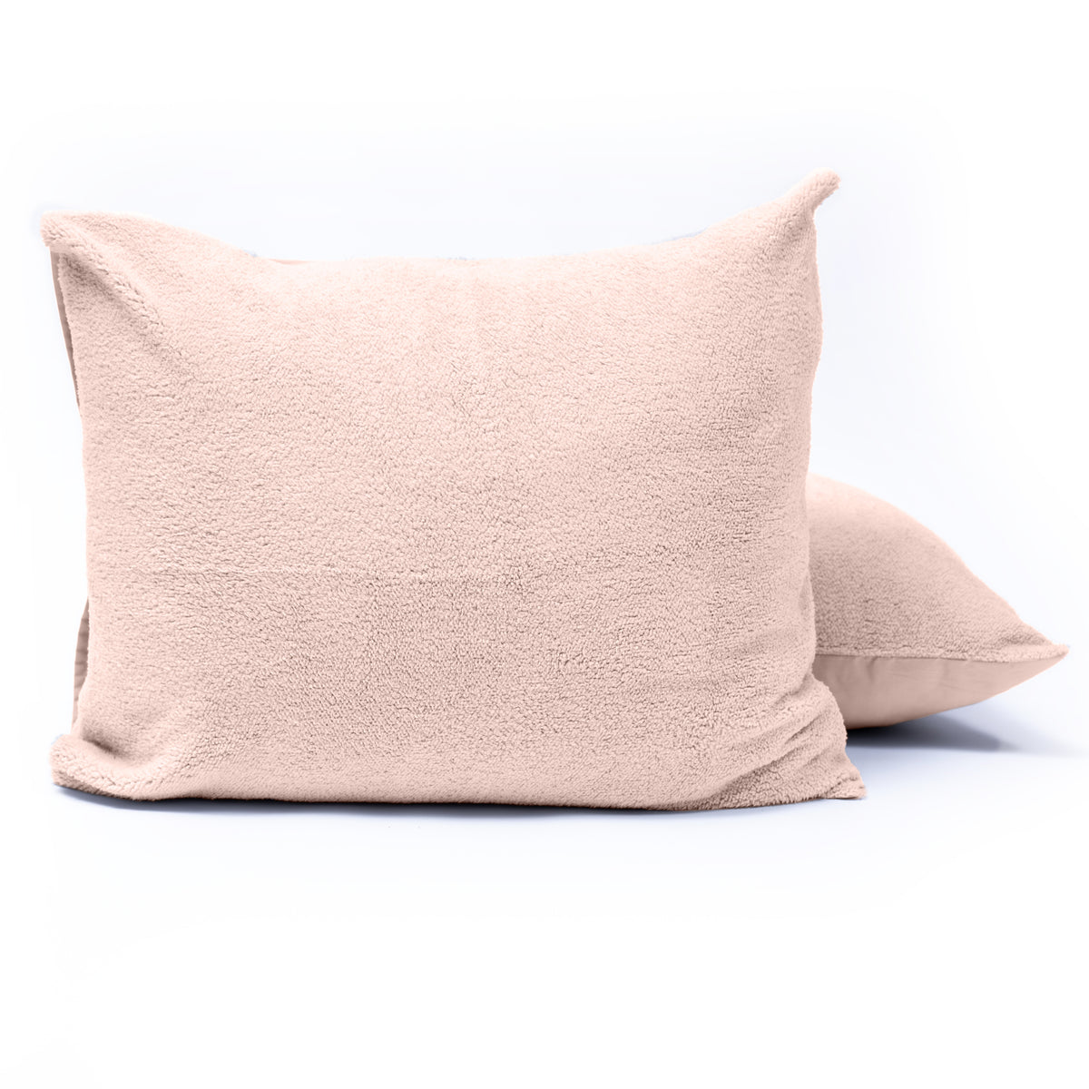 Twee roze teddy kussenslopen om kussens, één voor en één schuin erachter, op een witte achtergrond