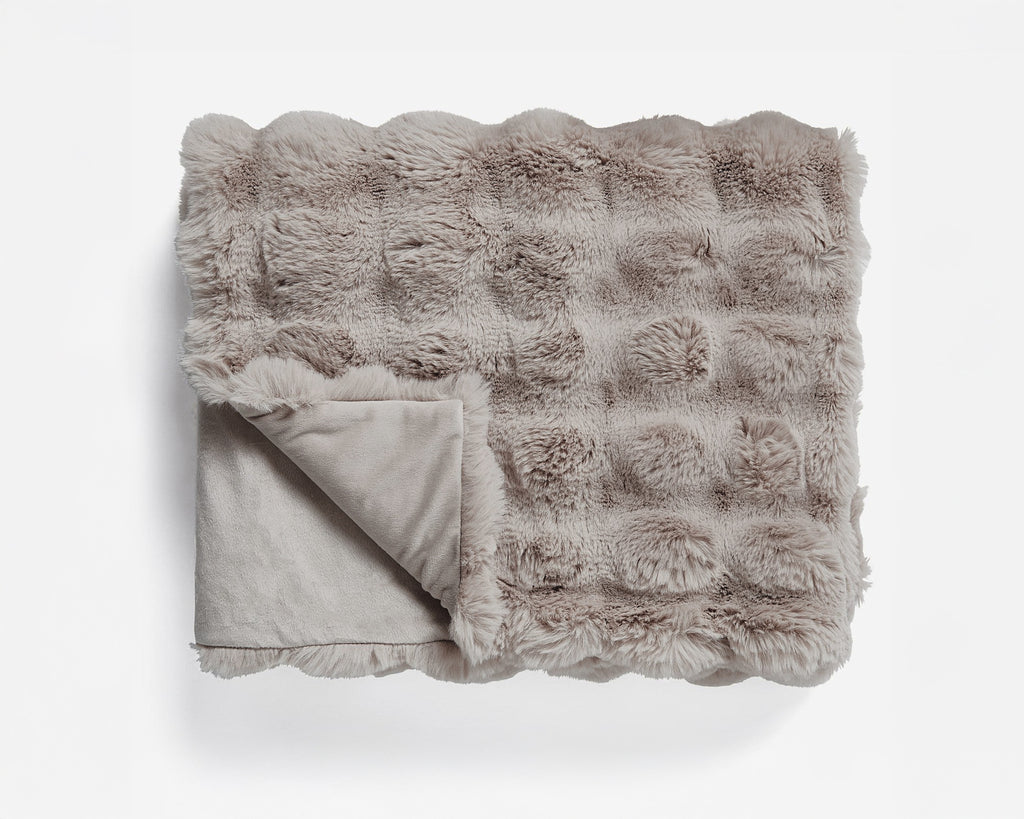 Gevouwen taupe plaid van imitatie konijnenbont met blokpatroon en een omgeslagen hoek van de gladde onderzijde