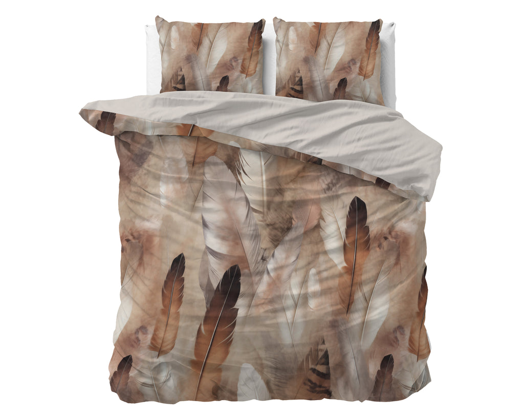 Dekbedovertrek met veren print in bruin en beige, uni taupe binnenkant en twee bijpassende kussens op een bed