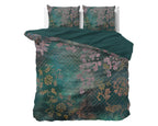 Groen dekbedovertrek met roze bloemen en goudkleurige ranken op een bed, met twee kussens en effen groene keerzijde