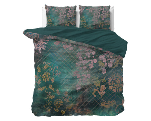 Groen dekbedovertrek met roze bloemen en goudkleurige ranken op een bed, met twee kussens en effen groene keerzijde