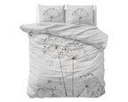 Wit dekbedovertrek met bloemenprint in taupe en bruin, met twee kussens op een bed
