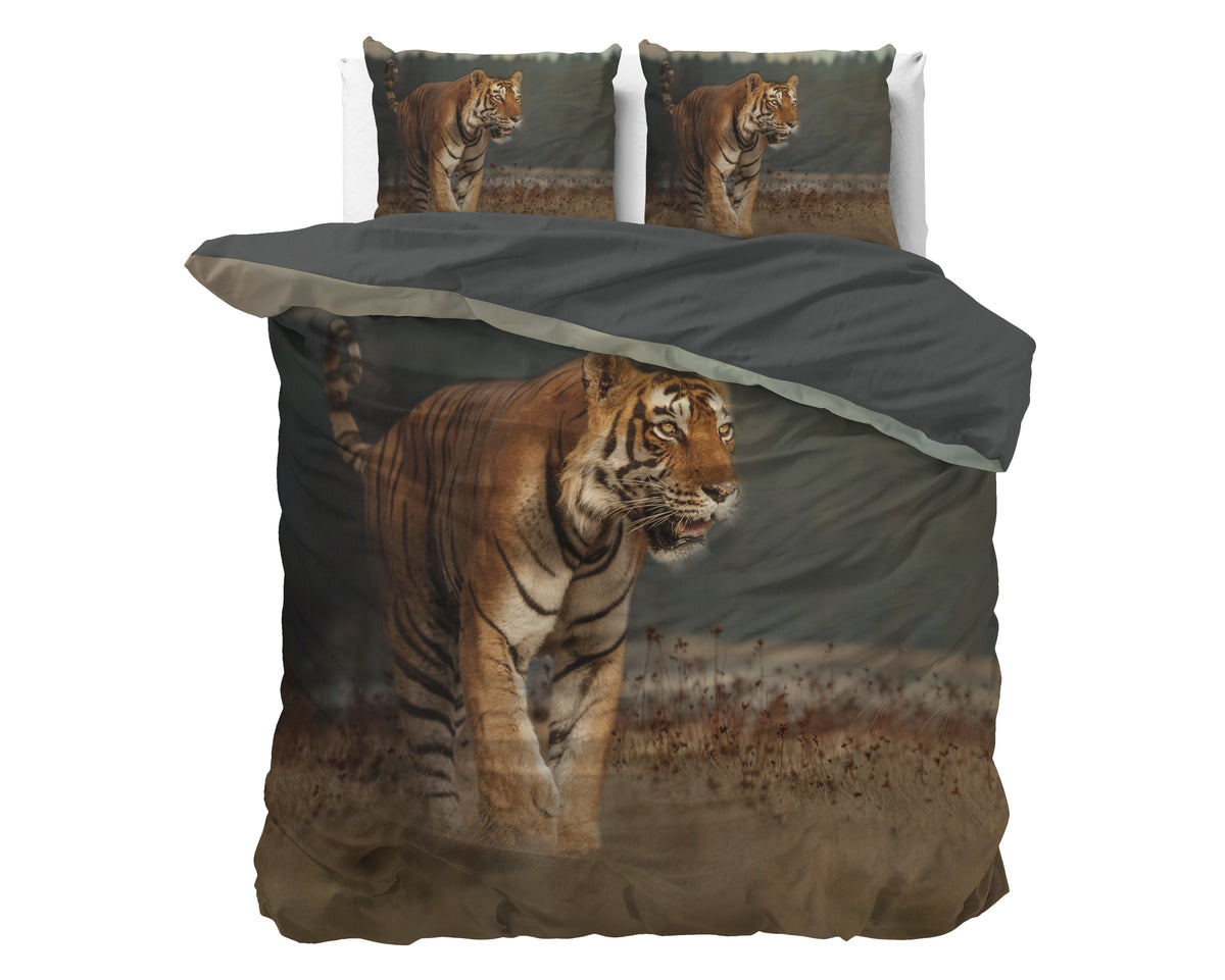 Bed met dekbedovertrek met print van een wandelende tijger en twee kussens met dezelfde print, donkergrijze achterkant