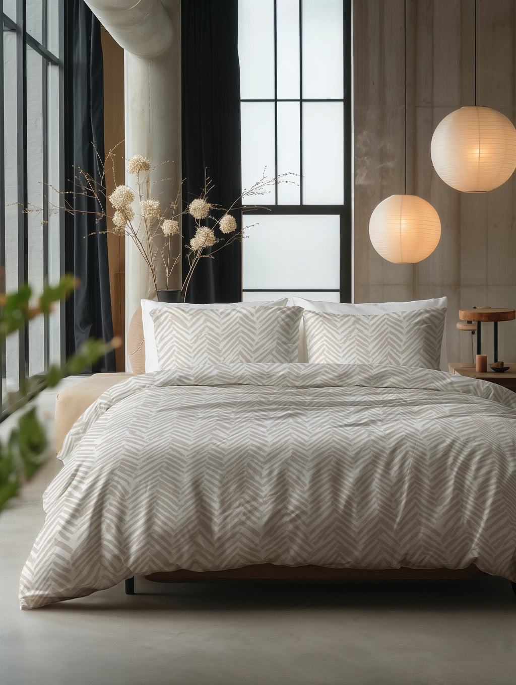 Bed met zandkleurig dekbedovertrek met visgraatmotief en bijpassende kussenslopen in een ruime slaapkamer