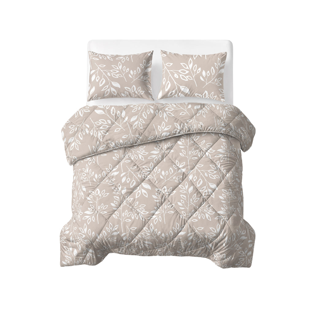 Opgemaakt bed met taupe/zand lazy dekbed met wit bladmotief, ruitvormige stikking en twee bijpassende kussens