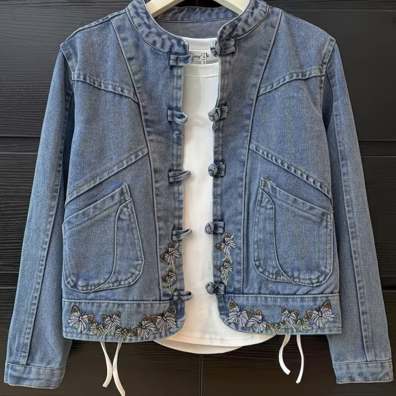 Women's denim jacket with stand-up collar, frog closures, and embroidery