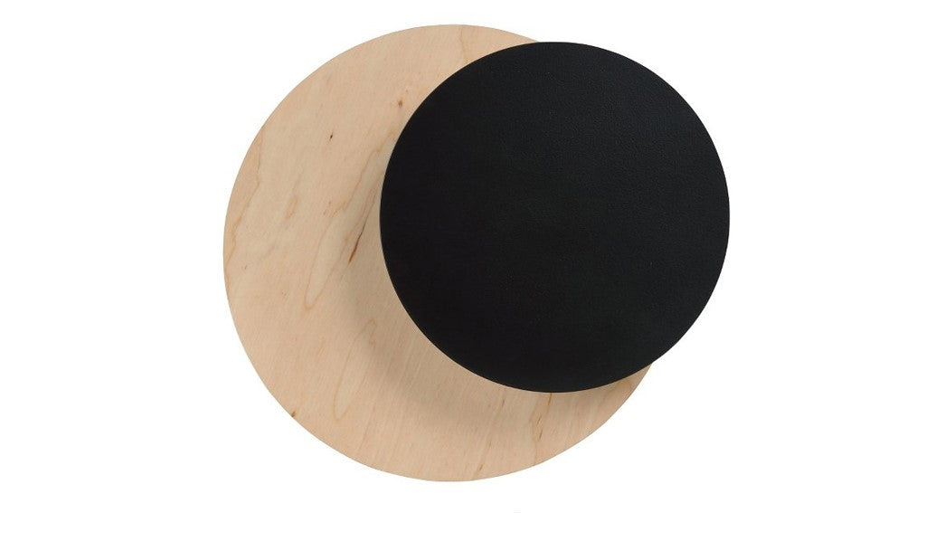 Ronde zwarte wandlamp die overlapt met een ronde plaat van licht multiplex