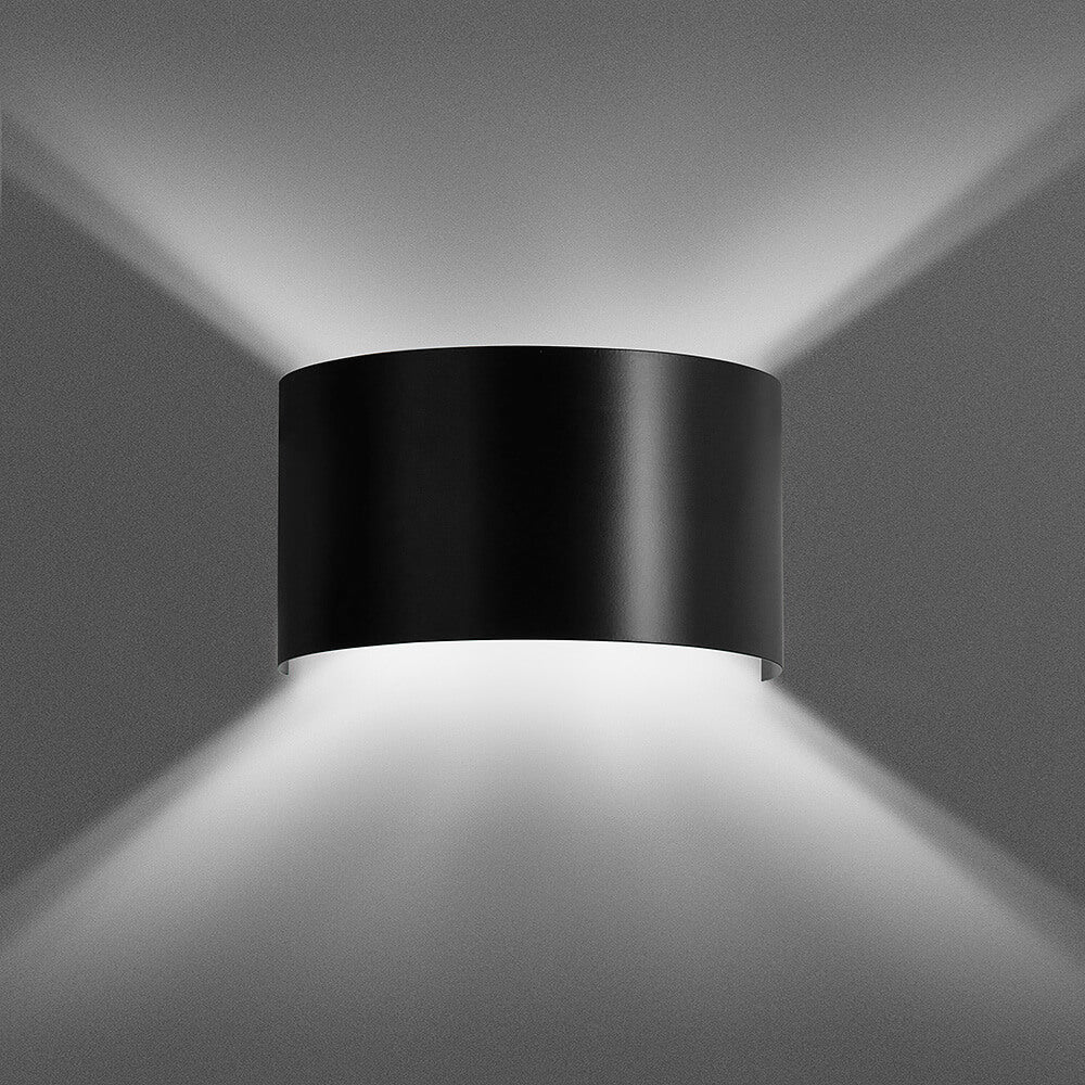 Zwarte halfronde wandlamp die zacht licht naar boven en beneden over de muur werpt