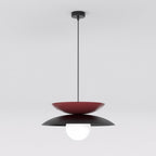 Hanglamp met bordeauxrode en zwarte metalen schijven en een witte glazen bolkap aan een dunne zwarte stang