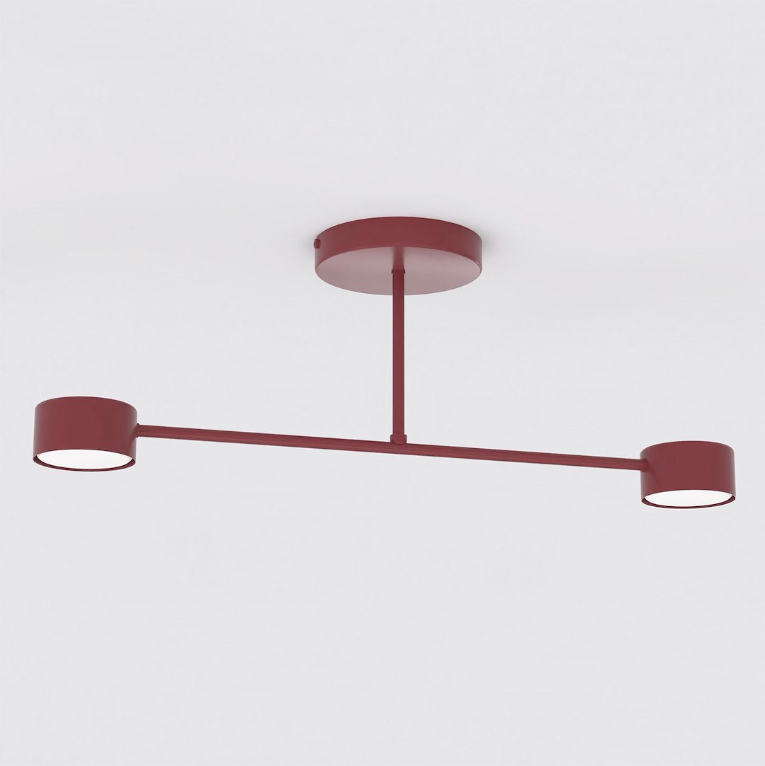 Bordeaux plafondlamp met dunne kruisarm en twee ronde lichtkappen aan een ronde plafondplaat