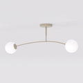 Beige plafondlamp met gebogen arm en twee witte glazen bolkappen tegen een lichte achtergrond