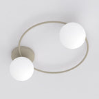 Plafondlamp met beige cirkelvormig frame en twee witte glazen bollen tegen een lichte achtergrond