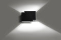Mat zwarte wandlamp met twee hoekige vlakken die licht omhoog en omlaag over een grijze muur werpt