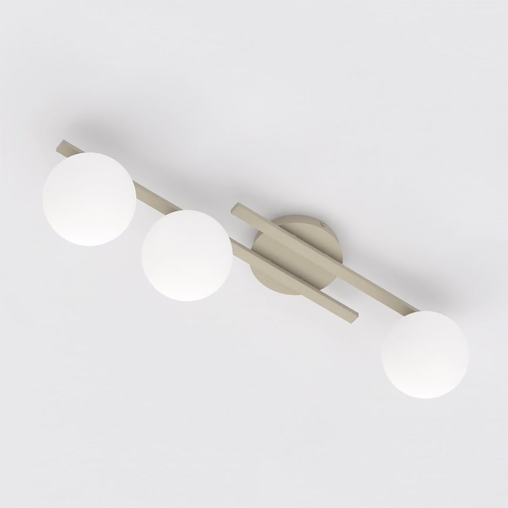Beige plafondlamp met drie armen en drie witte glazen bollen, gezien van onderaf tegen een wit plafond