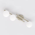 Beige plafondlamp met drie armen en drie witte glazen bollen, gezien van onderaf tegen een wit plafond