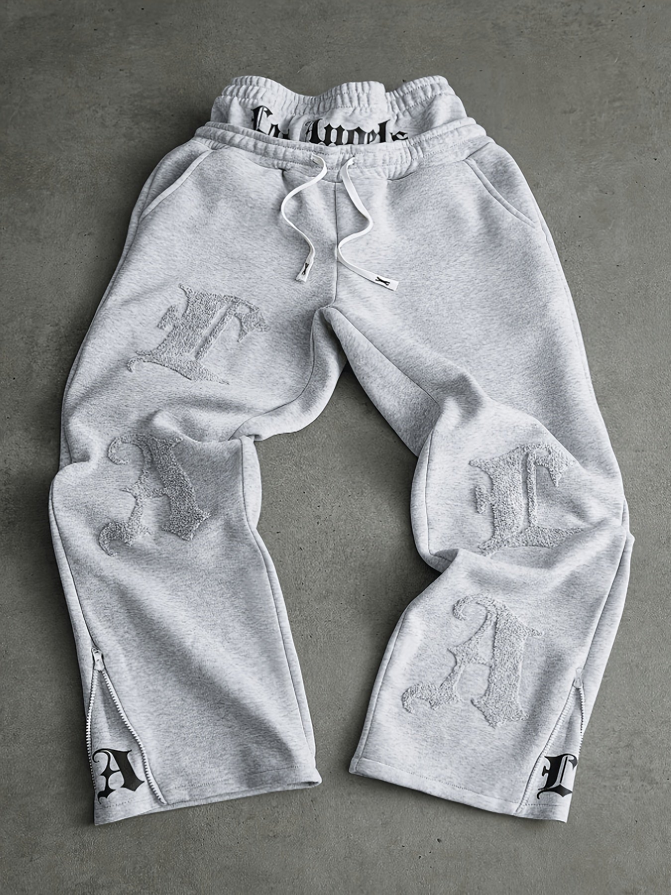 Loose-fit men's joggers with embroidered lettering on the legs, drawstring waistband, black