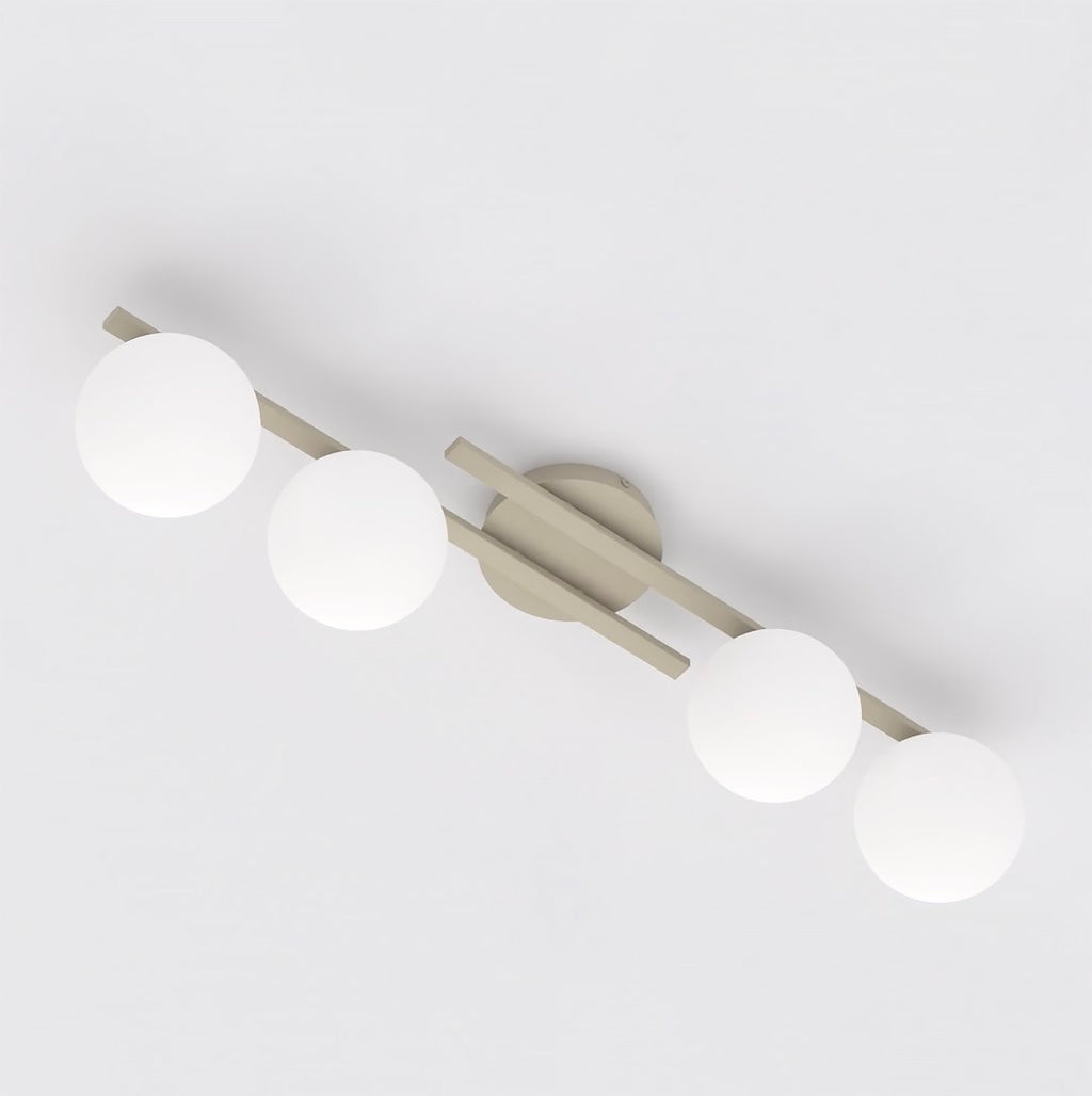 Beige plafondlamp met vier witte glazen bollen op een rechte metalen balk met ronde plafondplaat