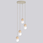 Beige hanglamp met vier snoeren op verschillende hoogtes, elk met een houten bol en een witte bolvormige kap