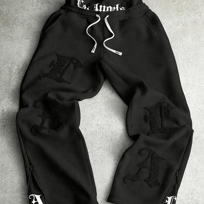 Loose-fit men's joggers with embroidered lettering on the legs, drawstring waistband, black