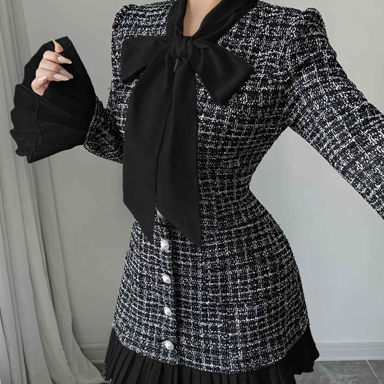 Black-and-white checked dress with a bow and pleated details